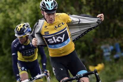 Chris Froome se quita su chuvasquero durante la carrera en la Dauphine Criterium el 9 de junio de 2013.