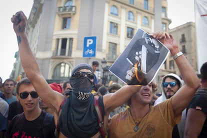 A protester burns a photo of King Felipe of Spain.