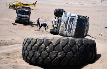 Un grupo de personas intenta enderezar el camin conducido por Michel Saumet y Xavier Tancogne que se accident durante la tercera etapa del Dakar entre Pisco y San Juan de Marcona (Per), el 8 de enero.