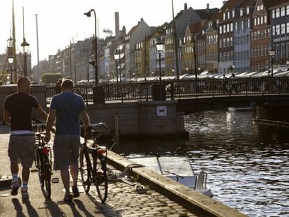 Dos ciclistas paseando junto a uno de los canales de Copenhague.