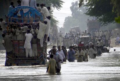 Paquistaníes escapan de las inundaciones en Basera, cerca de Muzaffargarh, en la provincia paquistaní de Punjab.