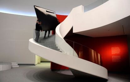 Operarios retiran una obra de Hugo Fontela de una de las últimas exposición con el actual equipo de gestión del Centro Niemeyer.