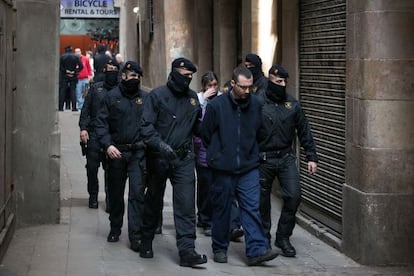 La policía lleva al supuesto líder de los Latin a un local donde se reunían, en 2014.