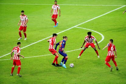 El delantero francés del FC Barcelona Antoine Griezmann (c), rodeado de jugadores del Atlético de Madrid. 