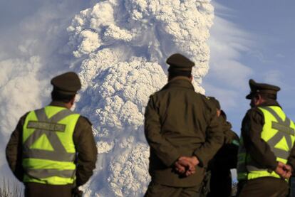 Varios policías observan el humo proveniente del volcán Puyehue-Cordon Maulle, de 2.240 metros de altura, que ha provocado una nube de ceniza de más de 10 kilómetros de altura.