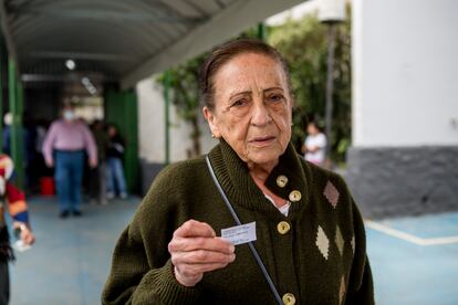 Ana María, de 75 años, muestra su comprobante. El papel lee "votar es una obligación cívica".