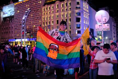 Una persona con la bandera LGBT+ entre los seguidores de Milei que festejan en el obelisco.