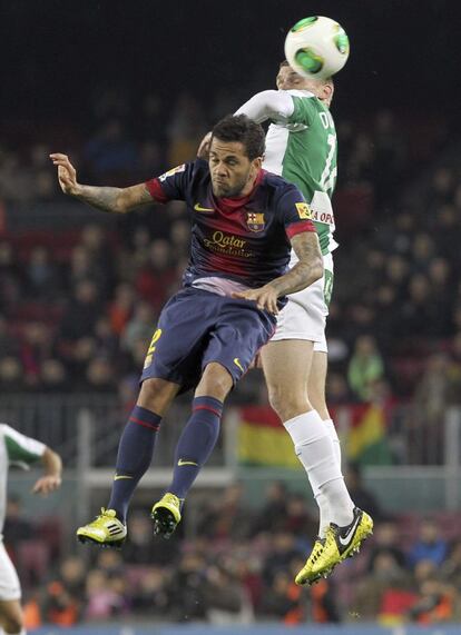 Alves y Dubarbier luchan por el balón en el aire.