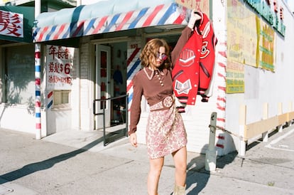 En el Chinatown de Los Ángeles con bomber oversize, minivestido y botas doradas, todo de Coach. Las gafas son el modelo Round Metal de Ray-Ban.