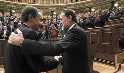 Mariano Rajoy (derecha) saluda al ya expresidente del Gobierno, José Luis Rodríguez Zapatero, tras ser investido en el pleno del Congreso.