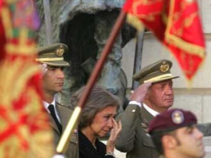 La Reina, entre el Rey y el Príncipe, enjugándose las lágrimas en un momento del funeral.