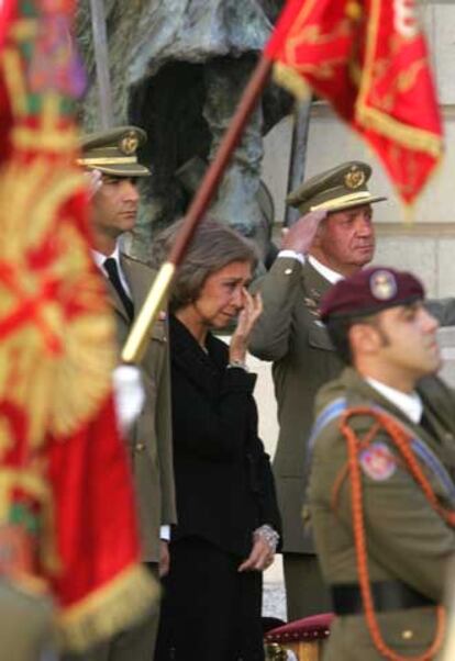 La Reina, entre el Rey y el Príncipe, enjugándose las lágrimas en un momento del funeral.