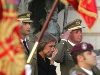 La Reina, entre el Rey y el Príncipe, enjugándose las lágrimas en un momento del funeral.