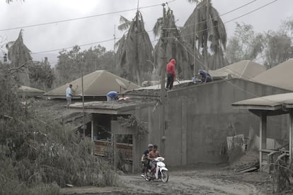 O chefe do Instituto de Vulcanologia e Sismologia das Filipinas (Phivolcs), Renato Solidum, alertou que a erupção não mostra sinais de desaceleração, embora a coluna de fumaça e cinzas tenha se reduzido, já que persistem os tremores causados pelo magma que continua subindo para a cratera. Na foto, os moradores tentam limpar os telhados de suas casas cobertas de cinza, em Laurel.