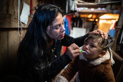 Patricia Rodriguez alista a su nieta Yoselyn para llevarla al jardín, en Soacha (Colombia), en julio de 2022.