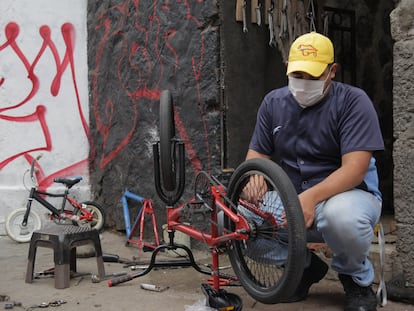 Jhoan Martín Machado repara una bicicleta en las calles de Quito (Ecuador), uno de los trabajos informales que realiza desde que llegara al país.