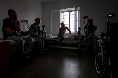 A la derecha, Vlad, mercenario de 25 años, junto a otros tres presos en una habitación del pabellón hospitalario del mayor campo de prisioneros de guerra rusos, en el oeste de Ucrania, el 25 de julio de 2024.