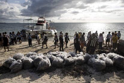 Voluntarios y funcionarios participan en la limpieza de la playa el 26 de abril de abril de 2018.