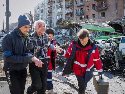 Personal sanitario atiende a un vecino herido tras unos bombarderos en Kiev, este lunes. Acnur cifra en algo más de 100.000 las personas que han llegado a Rusia huyendo de la escalada bélica en Ucrania. Las autoridades rusas han elevado este lunes a cerca de 250.000 esta cifra, según fuentes citadas por la agencia de noticias TASS.