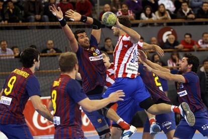 Parrondo, jugador del Atlético, lanza ante la oposición de la defensa azulgrana.