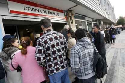 Desempleados hacen cola a las puertas de una oficina madrileña de empleo.