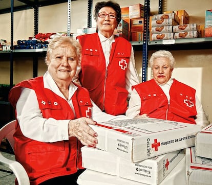 <strong>Julia, Matilde y Milagros. Estas tres voluntarias han dado un vuelco a sus vidas ayudando a los más necesitados. </strong> <p> Por <strong> Patricia Ortega Dolz </strong> <p> Las conocen como “Las chicas de oro”. Son Julia Docasal (77 años), Matilde Guillot (77) y Milagros Sánchez (72), tres señoras viudas que han salvado sus vidas colaborando en las campañas de la Cruz Roja de Tres Cantos (Madrid). La viudez hizo que recalaran en la organización humanitaria. Transformaron la búsqueda de las ganas de vivir en solidaridad. Hoy reparten alimentos una vez por semana, kilo a kilo, entre todos aquellos (“cada vez más, y cada vez más gente de clase media”) que lo necesitan según los dictámenes que emite la asistente social. Milagros lleva las cuentas de las cartillas de reparto porque, dice, fue contable en Renault durante años. Matilde, la elegante mujer de un marino mercante (“¡Ay, qué guapo era, con su uniforme!”), que funciona como un reloj tras haber trabajado durante años en la mítica joyería Grassy, “en el 1 de la avenida de José Antonio [Primo de Rivera]” (hoy la Gran Vía de Madrid), pone el sentido del humor necesario para hacer llevaderas las situaciones más trágicas y, si es necesario, se viste de lagarterana. Y Julia, curtida en la hostelería y que perdió de golpe y porrazo a su marido y a su hijo con seis meses de diferencia entre ambas muertes, despliega toda la psicología que entrena semanalmente con su psiquiatra. Las amarguras canalizadas por estas tres señoras, que un día creyeron perderlo todo y ahora dan todo lo que tienen, son menos amargas. Las tres juntas y en acción evocan, efectivamente, a aquella sitcom americana en la que cuatro señoras no podían vivir sin sus compañeras, pero tampoco sin tirarse los trastos a la cabeza en una competencia doméstica feroz. Con chaleco rojo o sin él, estas chicas de la Cruz Roja valen su peso en oro. <p> <hr /> <p> <strong> Patricia Ortega Dolz es periodista de El País. </strong> </p>