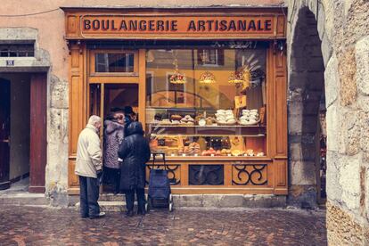 Algunos vecinos hacen cola en una panadería de la localidad francesa de Annecy.