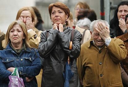 Tres familiares se lamentan a la salida del funeral