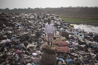 Mary, de siete años, posa sobre parte de los desperdicios generados por los habitantes de Old Fadama. No tienen un servicio de recogida de basuras por lo que las montañas de residuos se acumulan cerca de las casas.