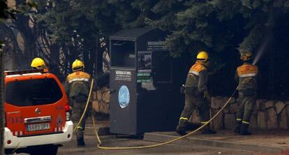 Un grupo de bomberos trabaja cerca de una zona habitada.