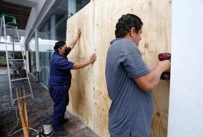 Las autoridades estiman que el paso del huracán provoque lluvias torrenciales en Jalisco y Nayarit, así como lluvias fuertes en Sinaloa. En la imagen, trabajadores protegen las ventanas de un hotel en Mazatlán.
