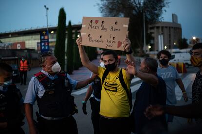 Dos mossos tratan intervienen este martes en una pequeña protesta en las inmediaciones del Camp Nou por la posible salida de Messi.