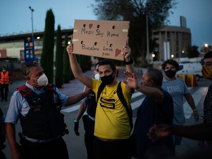 Dos mossos tratan intervienen este martes en una pequeña protesta en las inmediaciones del Camp Nou por la posible salida de Messi.