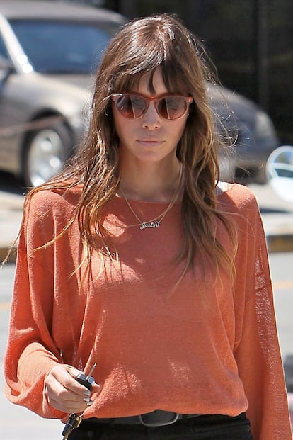 Jessica Biel con jersey de punto naranja y jeans negros en Los Ángeles. La actriz luce al cuello el nombre de su prometido, Justin Timberlake. El detalle: sus uñas en gris metalizado.