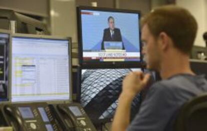 Un operador en Londres observa la comparecencia del primer ministro escoc&eacute;s, Alex Salmond.