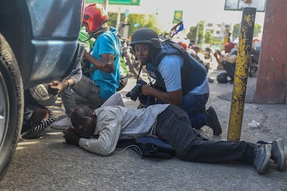 Un periodista se protege durante un tiroteo en Puerto Príncipe, Haití, este lunes.