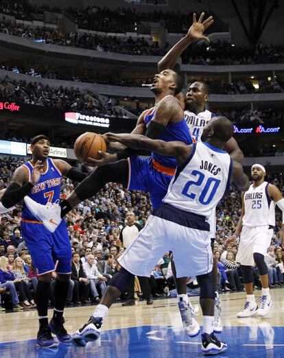 J.R. Smith, de los Knicks, intenta entrar a canasta ante dos jugadores de Dallas Mavericks