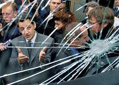 Nicolas Sarkozy contempla el cristal de un camión, fracturado en un enfrentamiento de la policía con jóvenes manifestantes en Estrasburgo.