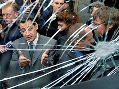 Nicolas Sarkozy contempla el cristal de un camión, fracturado en un enfrentamiento de la policía con jóvenes manifestantes en Estrasburgo.