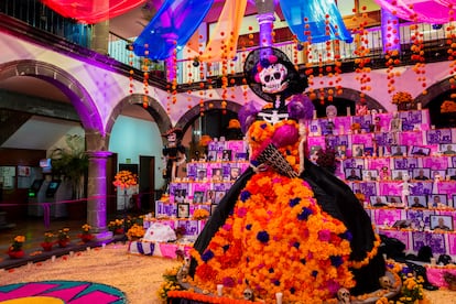 Figura de "La Catrina" frente a un altar de los muertos.