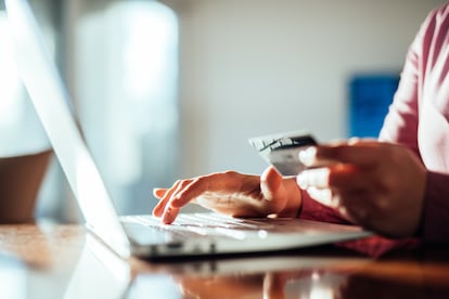 Woman shopping with a credit card at home.