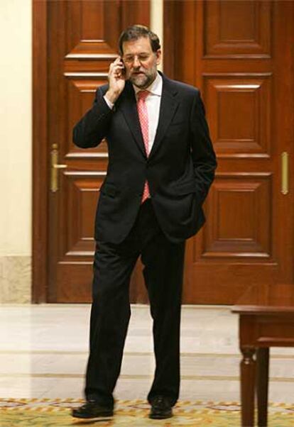 El líder del PP, Mariano Rajoy, habla por teléfono en el Congreso.