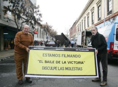 El escritor Antonio Skármeta (izquierda) y el director Fernando Trueba, en una calle de Santiago de Chile con una pancarta de la película.