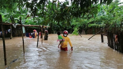 Un bombero rescata a una niña de una zona inundada durante el huracán Eta, en la ciudad de Tela (Honduras), en noviembre de 2020.