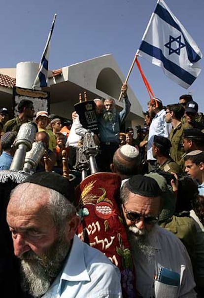 Colonos de Netzarim sacan los rollos de la Torá de la sinagoga del asentamiento.