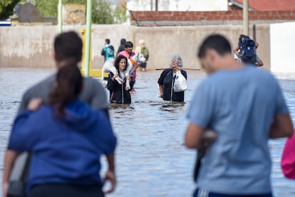 Familias evacúan sus hogares a través de calles inundadas, este sábado en Bahía Blanca.