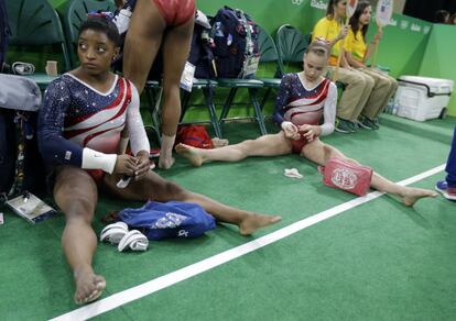 Las estadounidenses Simone Biles y Madison Kocian descansan antes de sus ejercicios.
