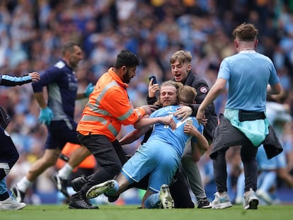 Los hinchas abrazan a De Bruyne tras el pitido final en el Etihad.