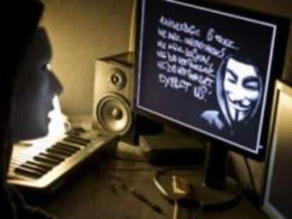 Una usuaria mira a una pantalla donde aparece un mensaje de Anonymous.
