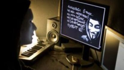 Una usuaria mira a una pantalla donde aparece un mensaje de Anonymous.